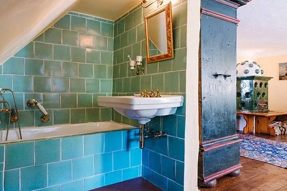 Teal-tiled ensuite bathroom with brass fixtures in the Courtyard Ensuite Room
