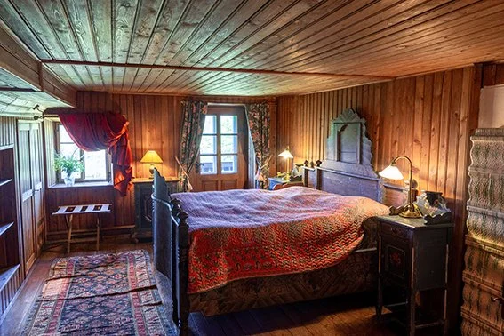 Carved iron bed with a red curtain drape in the Double Room