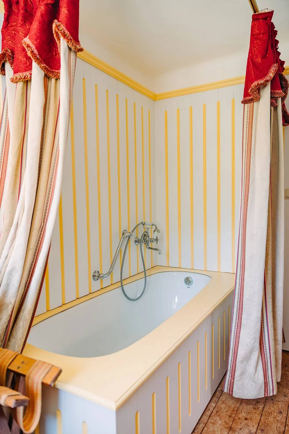 Yellow-panelled bathtub in the Single Room With Bath